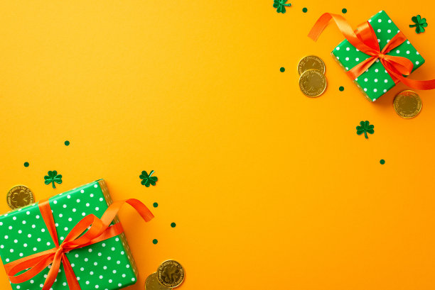 圣帕特里克节的概念。顶部视图照片绿色礼盒与橙色丝带蝴蝶结金币和三叶草形状的五彩纸屑孤立的黄色背景与空白图片下载