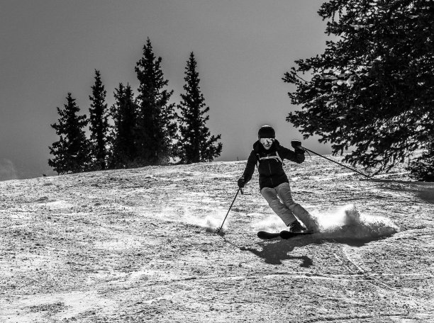 高对比度黑白图像。成熟的女子滑雪者身后有天空。科罗拉多州阿斯彭的雪场。图片下载