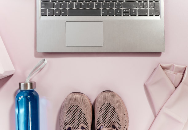健身、瑜伽配件套装。胸罩，瑜伽用的粉色积木，装水的瓶子，哑铃，运动鞋，跳绳，粉红色背景的笔记本电脑。运动装备，极简的背景。近距离图片下载