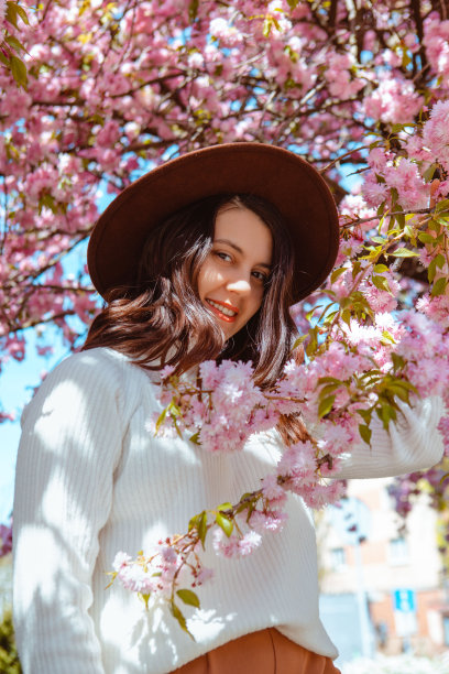 美丽的高加索妇女与盛开的樱花樱花树的肖像图片下载