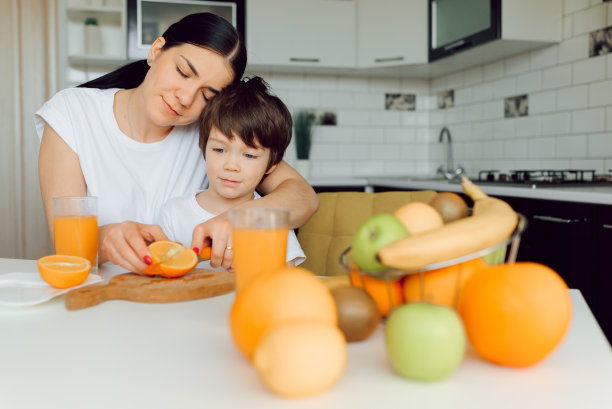 健康生活和饮食理念。健康饮食。妈妈带着宝宝喝果汁吃水果图片下载