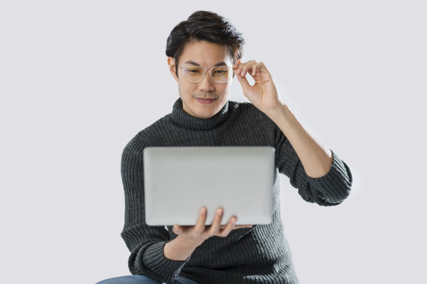 聪明迷人的亚洲成熟成年男性戴眼镜手使用笔记本电脑在线工作室商店白色背景，男子穿着毛衣休闲布微笑自信和积极的情绪图片下载