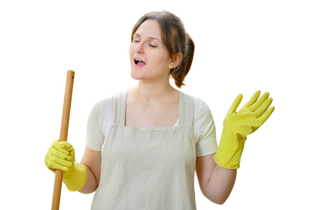 一个快乐的女人拿着拖把在厨房里唱歌，厨房被隔离在白色的背景上图片下载