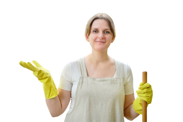 一个幸福的女人在白色背景下的家庭厨房里打扫卫生，微笑着看着镜头图片下载