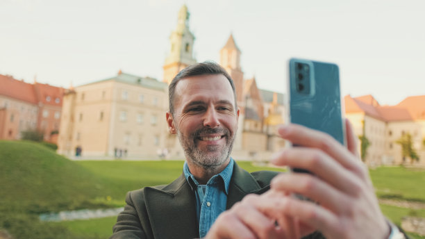 一名男子在旧城背景下用手机自拍图片下载