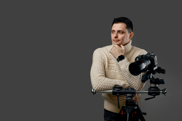 摄影师穿着毛衣，三脚架上有数码相机图片下载