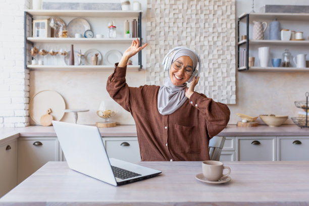 戴着头巾、在家听音乐的年轻阿拉伯女商人自由职业者图片下载