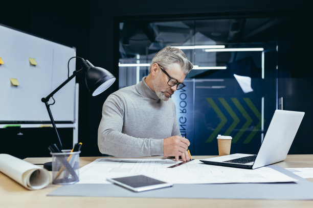 一个资深的建筑师，设计师，工程师用铅笔在纸上画一张图，做一个计划图片下载