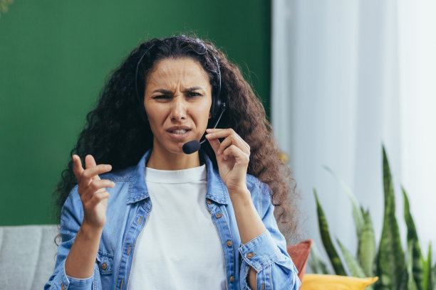 戴着耳机在家工作、不悦的西班牙裔顾问图片下载