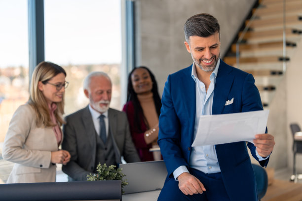 微笑的商人团队领导看着纸质项目文件，在工作中分析财务报告图片下载