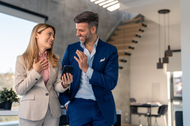 微笑友好的专业同事用智能手机站在现代化的城市办公室，讨论项目，分享想法，一起工作图片下载