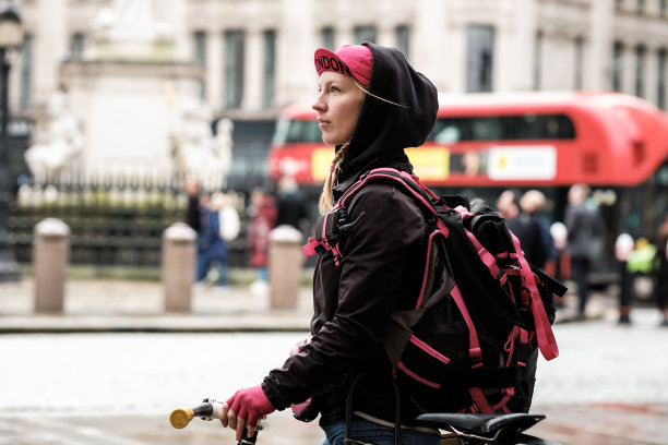 自行车快递员在繁忙环境中的侧面肖像。图片下载