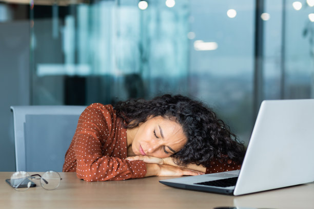 在办公桌上睡觉的疲惫的西班牙裔女人，在笔记本电脑附近办公室里闭着眼睛小睡的特写女商人图片下载