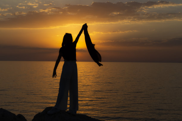 日落时比V字手势的女性游客图片下载