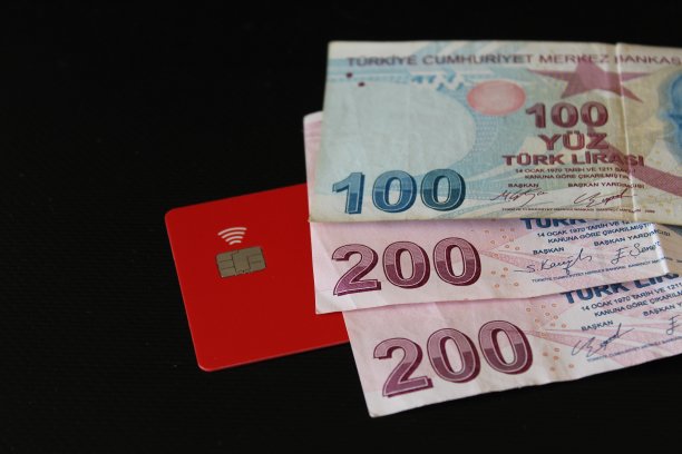 纸质钞票，土耳其铁硬币和信用卡的黑色背景。100磅和200磅。经济和金融。图片下载