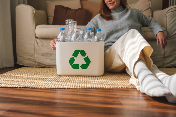 特写图像的妇女收集和分离可回收的垃圾塑料瓶在家里的垃圾桶图片下载