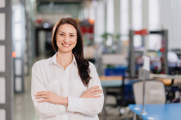 办公室里一个穿白衬衫的褐发女人。商业画像。图片下载