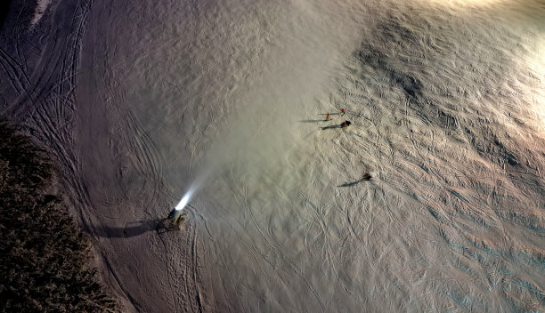 从高处观察滑雪者在下坡道上的行为。水炮人工造雪。把一股水流射到有凹槽的表面上。昂贵的能源密集型技术图片下载