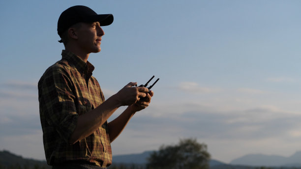 年轻的农民在日落时分使用无人机图片下载