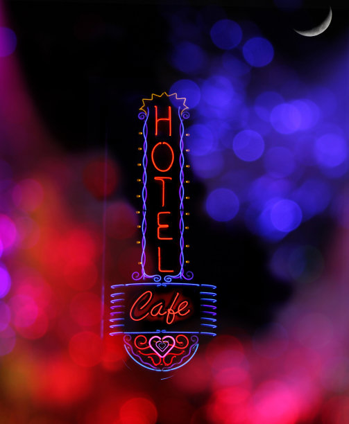 垂直拍摄的霓虹灯酒店和咖啡馆的标志与散景灯光效果图片下载