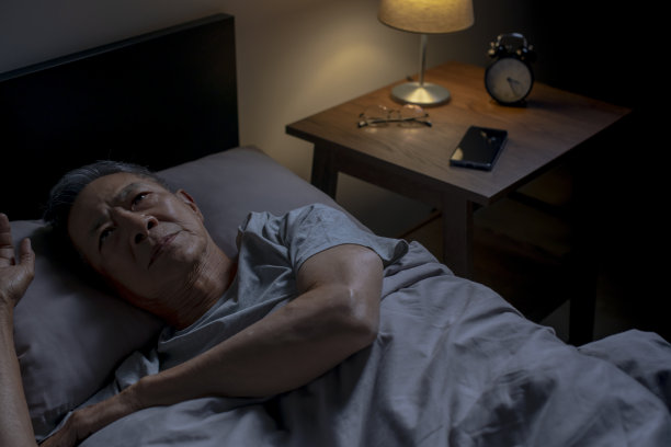 抑郁的亚洲老年男子躺在床上无法入睡，因为失眠图片下载