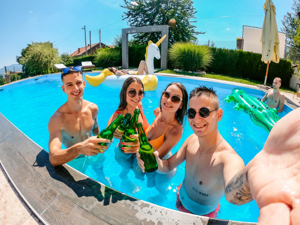 一群朋友在游泳池边喝啤酒边自拍图片下载