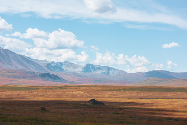 风景斑驳的秋季景观，阳光明媚的高原和山脉在戏剧性的多云天空下。山间秋色鲜艳。阳光和云的阴影在多变的天气。图片下载
