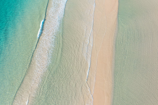 鸟瞰海滩，田园般的热带蓝色海水和温柔的海浪图片下载