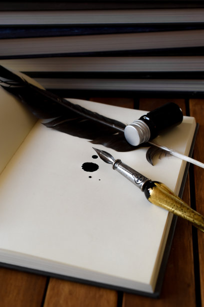 桌上有一支钢笔，一个墨水瓶和一本书。图片下载