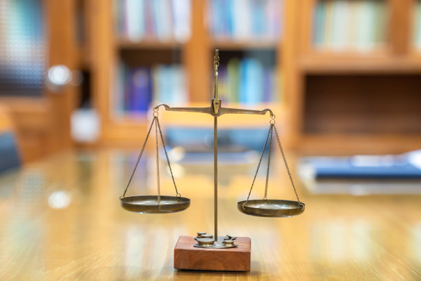 律师事务所会议室的木质玻璃桌上摆放着复古风格的旧黄铜法律秤。图片下载