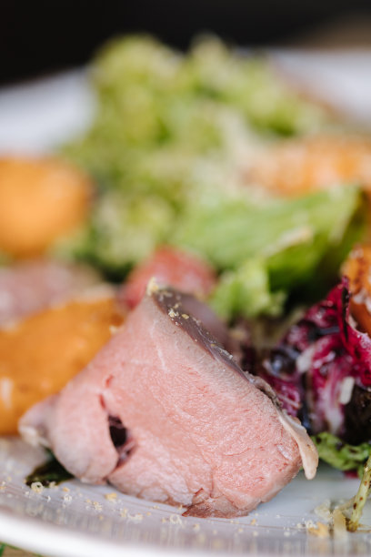 微距照片的温暖沙拉与小牛肉和杏。餐厅里美味的食物。木制的桌子图片下载