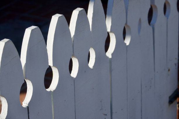 午后阳光下的老式白色尖桩篱笆图片下载