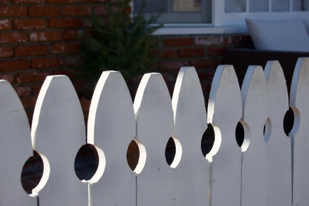 午后阳光下的老式白色尖桩篱笆图片下载