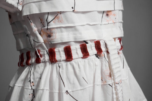 白色亚麻连衣裙部分绣有花纹，细部漂亮的连衣裙特写。选择性聚焦图片下载