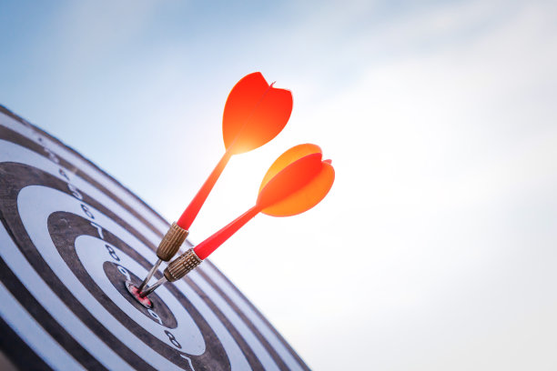 近距离射击红色飞镖箭头在靶靶中心在深蓝色的天空背景。商业目标或目标成功和赢家概念。图片下载