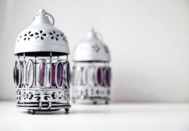 白色闪闪发光的背景上有两盏破旧的复古风格的银色灯笼图片下载