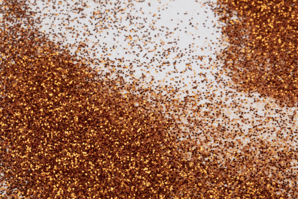 金色的亮片散落在白色的背景上。图片下载
