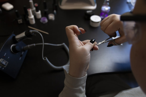女孩在背景上用美甲工具附近的美甲剪刀剪下角质层图片下载