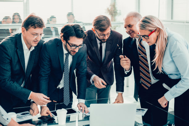 一群员工热情地看着笔记本电脑屏幕图片下载