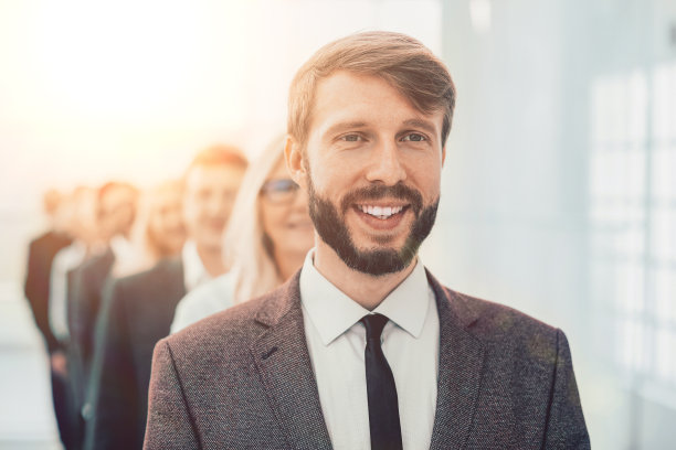 关闭了。一群快乐的员工站在办公室里。图片下载