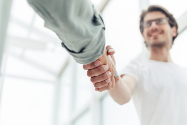 关闭了。年轻的企业家与他的商业伙伴握手图片下载