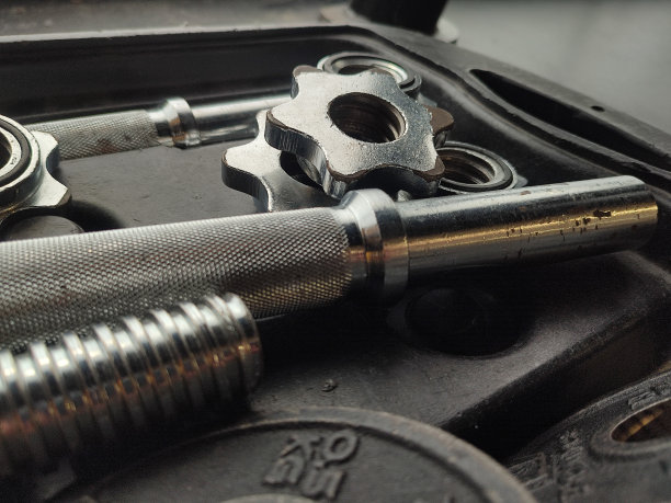 杠铃和坚果在他们的情况下，在健身房。图片下载