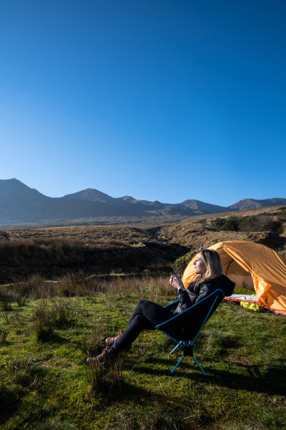 一名女子坐在露营椅上喝咖啡，爱尔兰克里基拉尼环图片下载