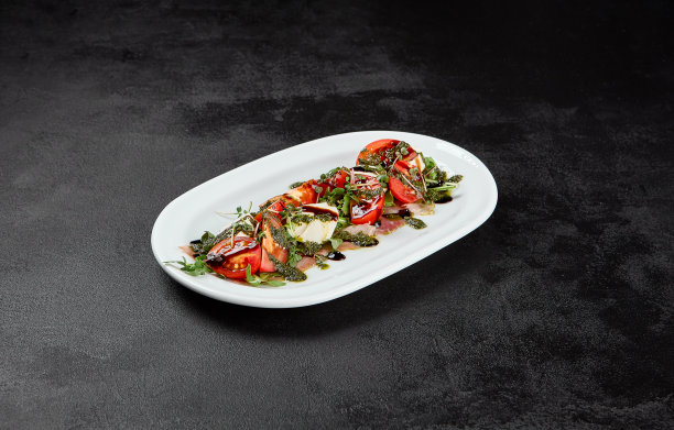 传统的意大利食物-卡普里沙律配马苏里拉芝士，西红柿和香蒜酱。卡布里沙拉在黑色混凝土背景在极简风格。深色背景上的意大利开胃菜图片下载