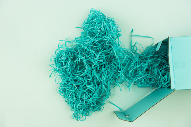 一堆蓝色的碎纸像鸟巢一样作为礼物的填充物图片下载
