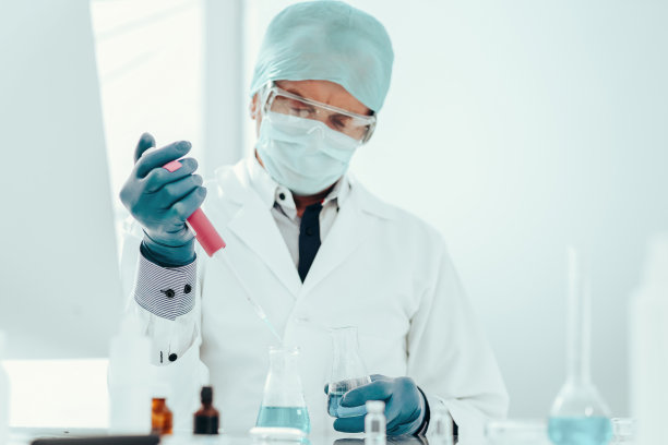 一名女科学家手持装有疫苗的安瓿。图片下载