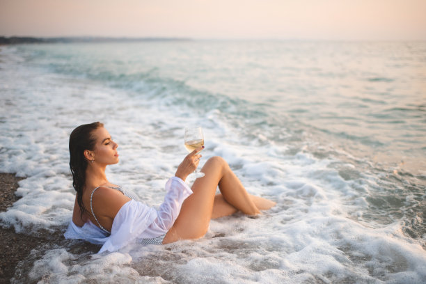 美丽的女人休息在海滩与葡萄酒户外图片下载