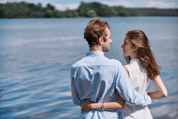 一对热恋的情侣正站在湖边聊天。图片下载