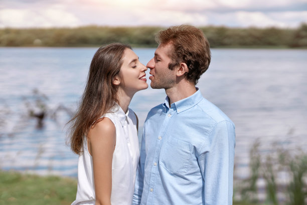 年轻夫妇在乡间散步时亲吻。图片下载