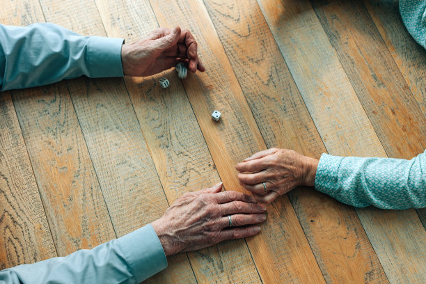 老年人的手在桌子上玩骰子的俯视图图片下载